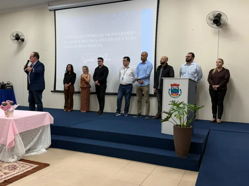 Mulher segurando certificado de curso de costura em cerimônia de formatura municipal