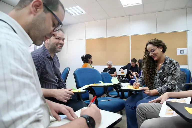 Mulher acessando a Escola Virtual Gov no celular em casa