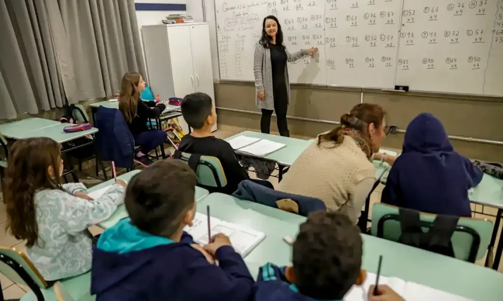Professora analisando material do curso 100 vagas MEC de matemática no computador