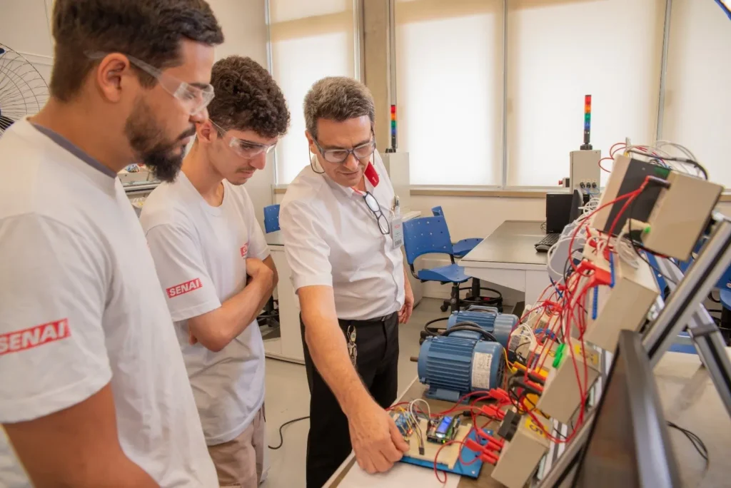 Jovem técnico em treinamento no SENAI Valinhos com equipamento eletroeletrônico industrial